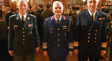 Three people in uniform in front of the camera
