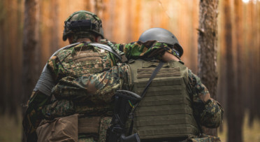 Two Ukrainian soldiers support one another during a training exercise.