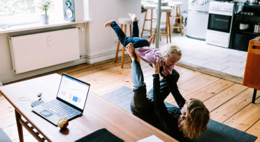 A woman playing with a child in a living room
