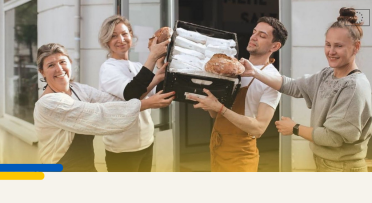 Picture of team of bakers holding a loaf of bread