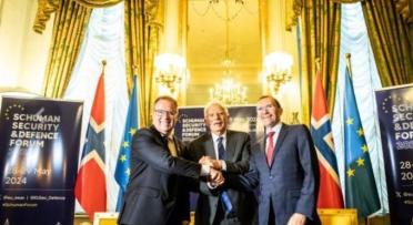 Three men shaking hands at a Schuman Forum event