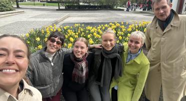 Gruppebilde ute foran blomster