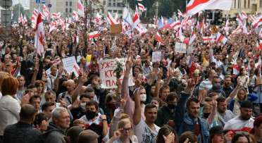 Large protest of people waving Belyorussian flags.
