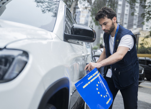 male observer putting sticker on his car