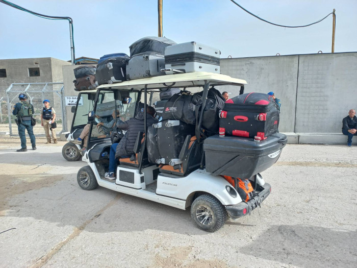 A white vehicle cart filled with suitcases.