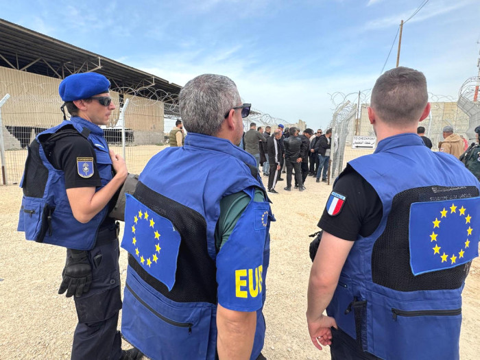 Exterior, civilian supervisors at border crossing. 