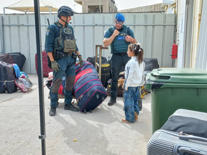 Two officers speak to a child. 