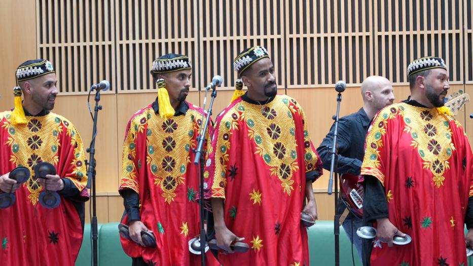 Four singers in red costumes on stage. 