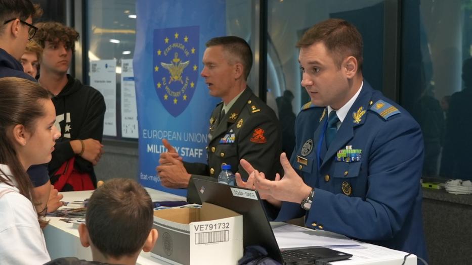 Military colleagues at a desk meeting the public.