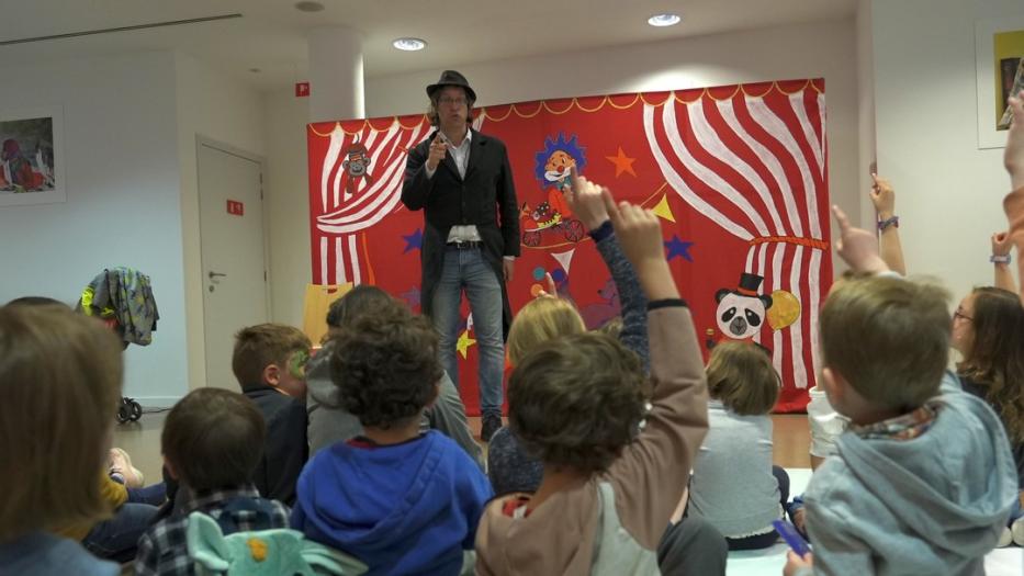 Children's entertainer and kids in the audience.