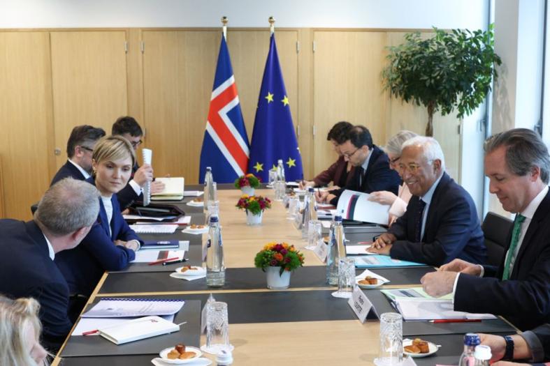 Picture of a meeting room with people at a large table