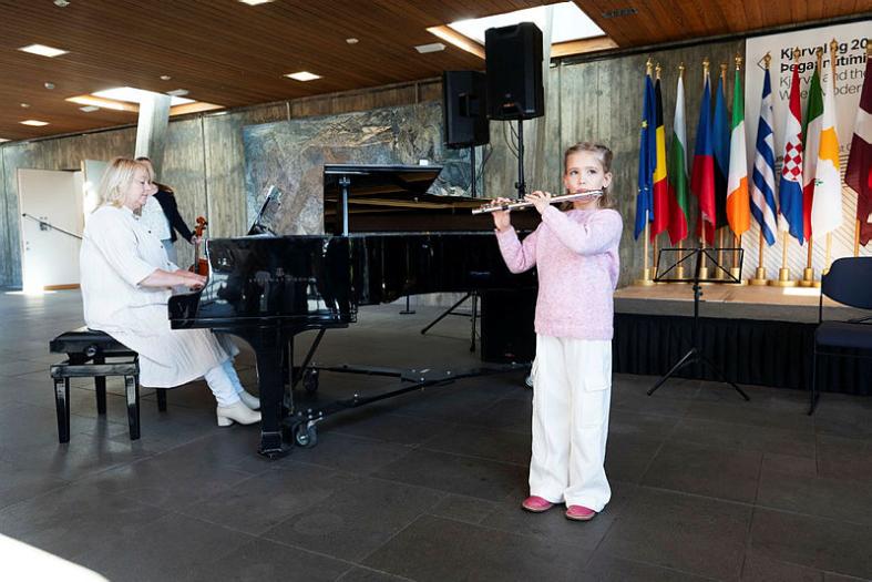 Picture of a young girl playing a clarinet with a pianist