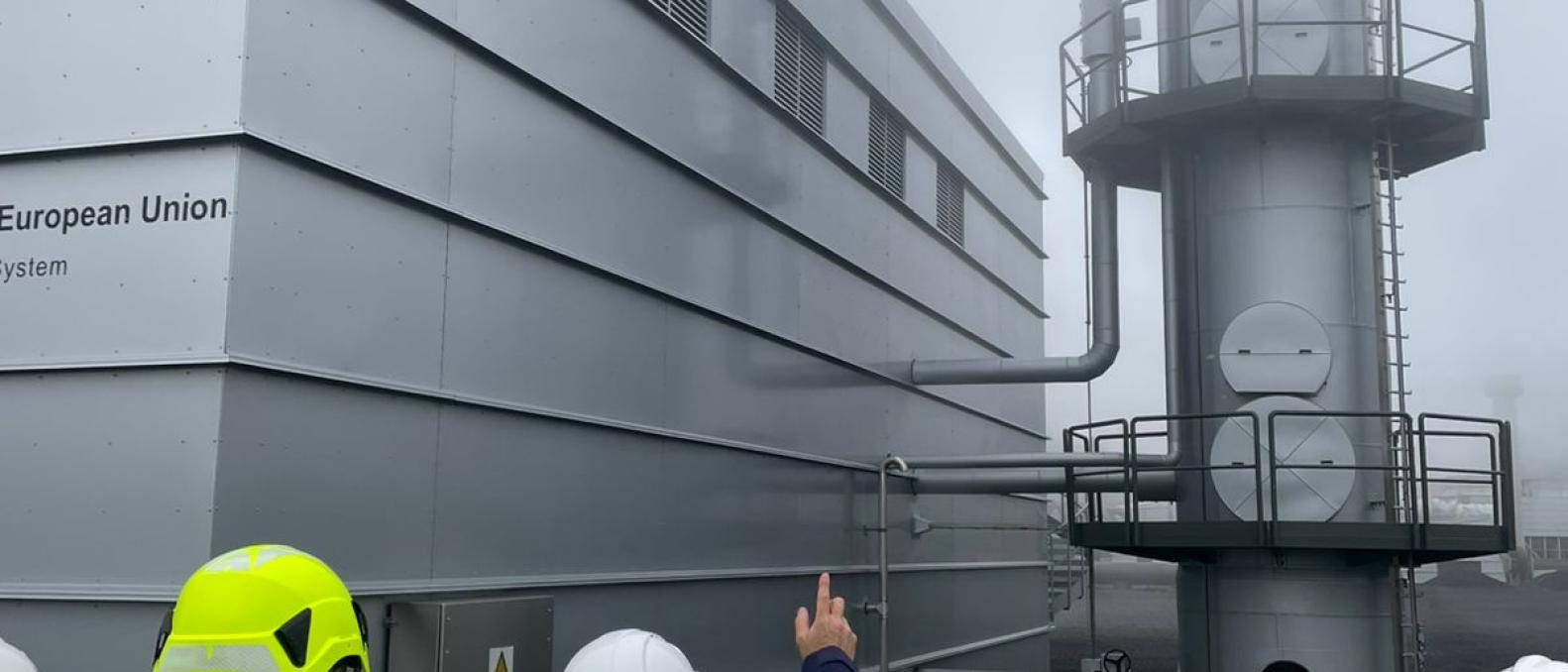 People in yellow jackets looking at a carbon capture facility