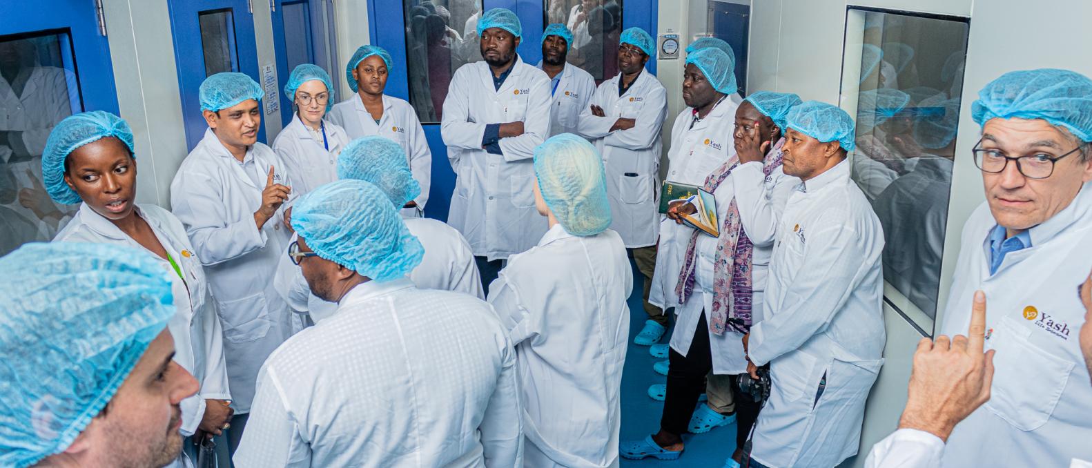 People in dressing gown and hairnet visiting a company