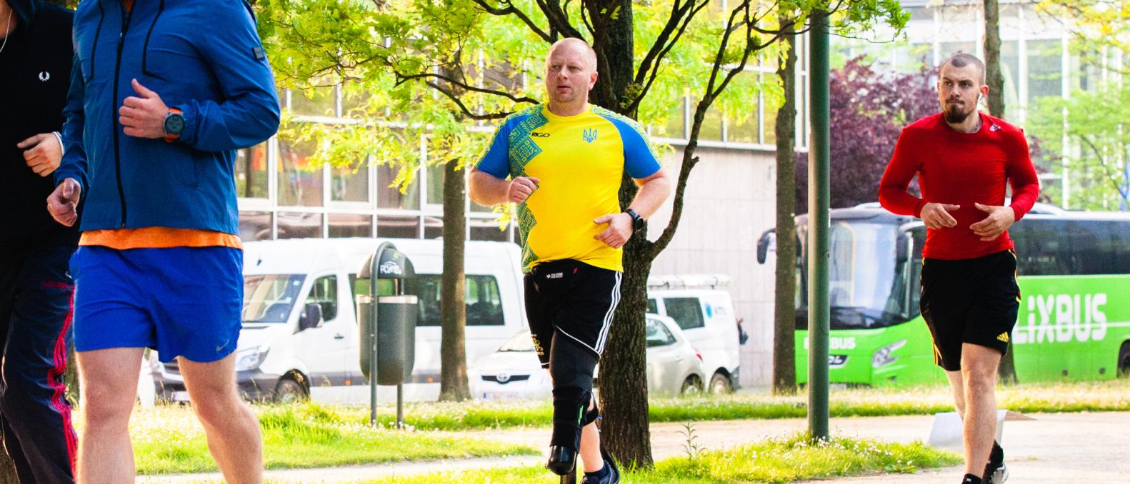 Three Ukraine athlete war veterans warm up for running.