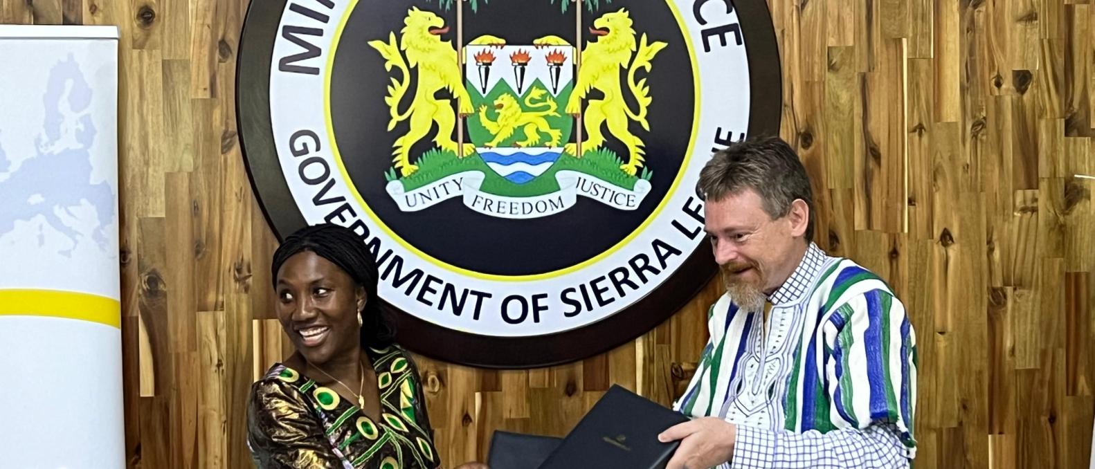 Deputy Minister of Finance, Ms. Kadiatu Alie exchnaging the signed agreement 