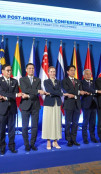 HRVP with posing with a line of VIP delegates on stage at a conference.
