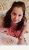 Girl sitting on the floor and surrounded by drawing