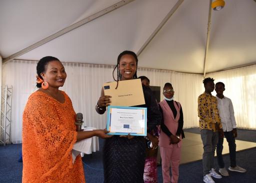 a woman giving a certificate to students 
