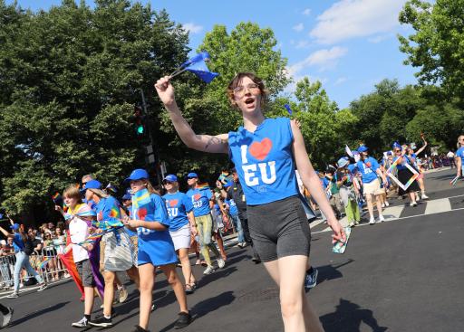An EU parade marcher waves to the camera.
