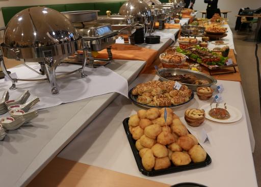 Photo of the whole buffet table (wider angle), metal containers on the left and food displayed on the right