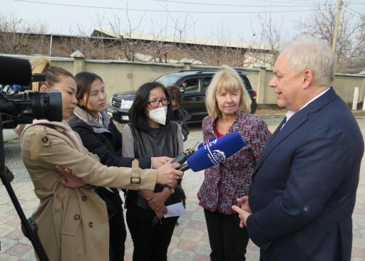 Reporter interviewing a person while three others listen.