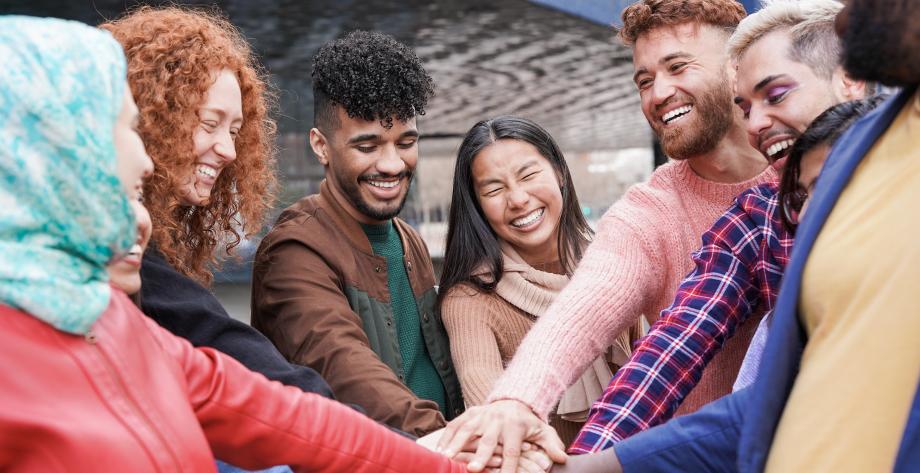 Group of young multiracial people stacking hands (Envato)