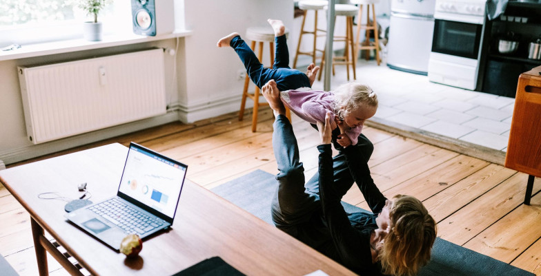 A woman playing with a child in a living room