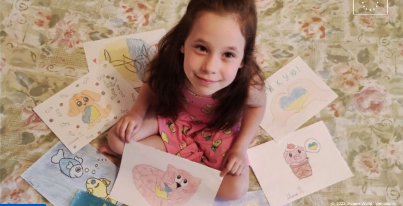 Girl sitting on the floor and surrounded by drawing