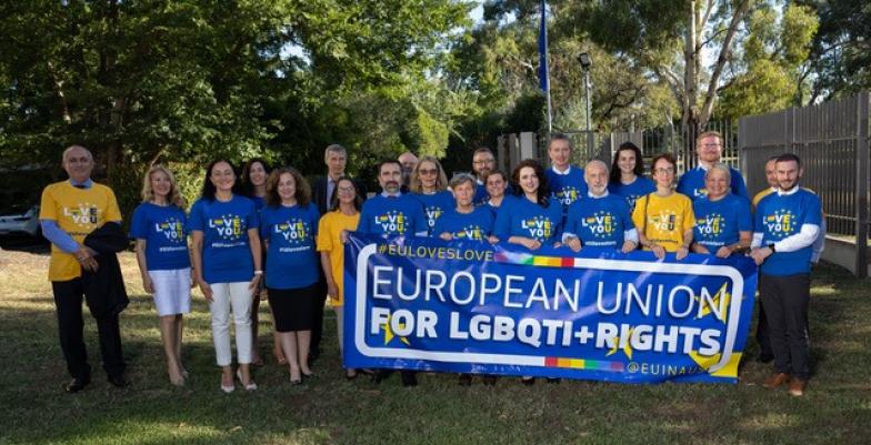 group of people in LGBTIQ+ tshirts with banner