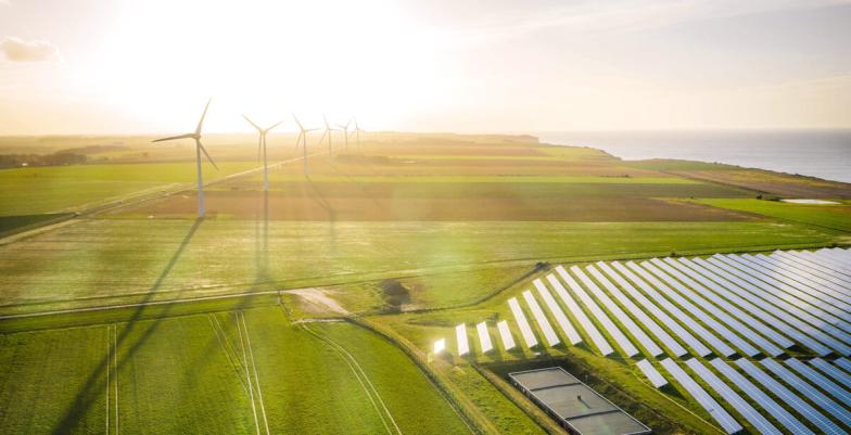 Wind turbines, green fields, ocean and solar panels for Green Transition concept. 
