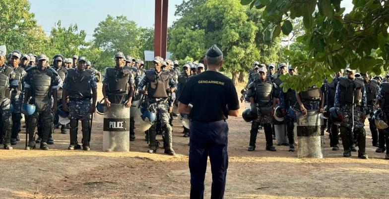 A troop of police officers stand to attention facing the camera.