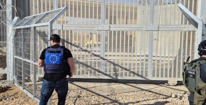 EU civilian employee opens gate at border checkpoint in Rafah.