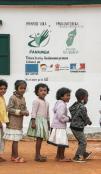 Enfants en file indienne devant un mur