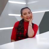 Young brown hair lady with red shirt, sitting at a table and smiling naturally at the camera