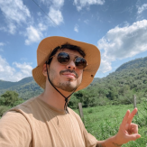 Young adult man with short brown hair and a hat