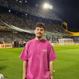 One of our campaign influencer Lucas in a soccer stadium, standing and smiling at the camera