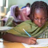Kid writing in a paper