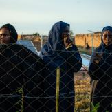 Women leaning on a fence