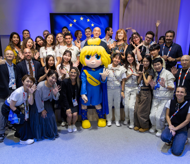 A crowd of people with Europa, the official mascot of the EU pavilion at World Expos Osaka