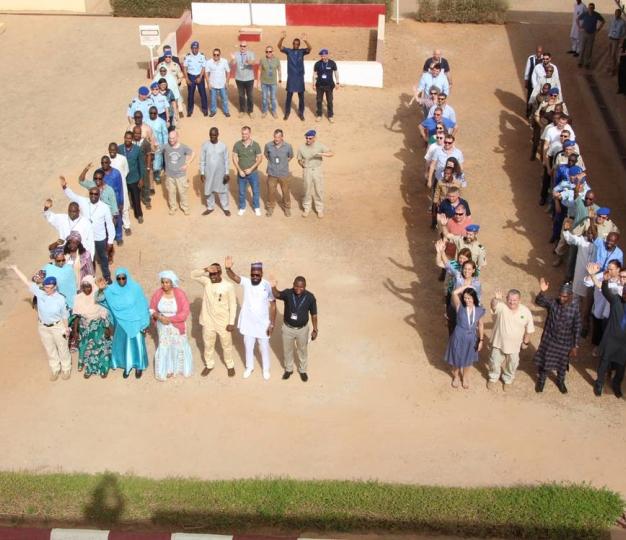 People arranged in a family photo making the letters EU.
