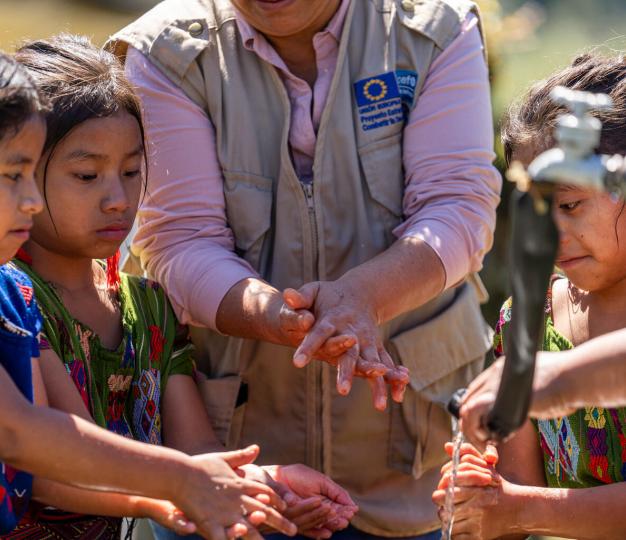 Foto de niñas indígenas del área rural con técnico del proyecto UE-UNICEF sobre acceso a saneamiento e higiene