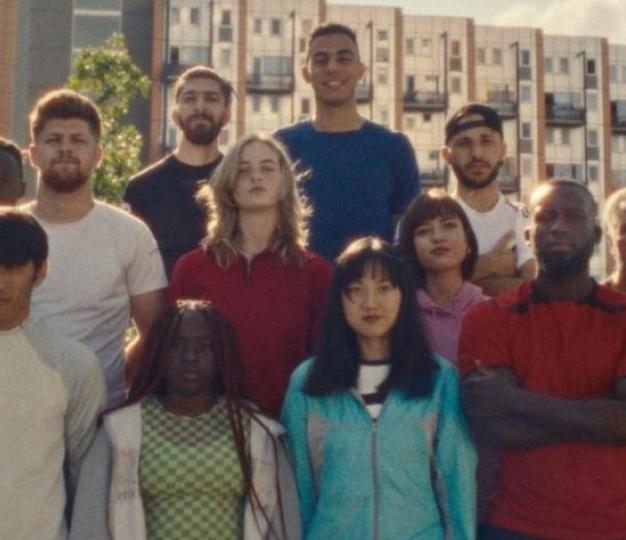 group of people from different origin standing and looking at the camera