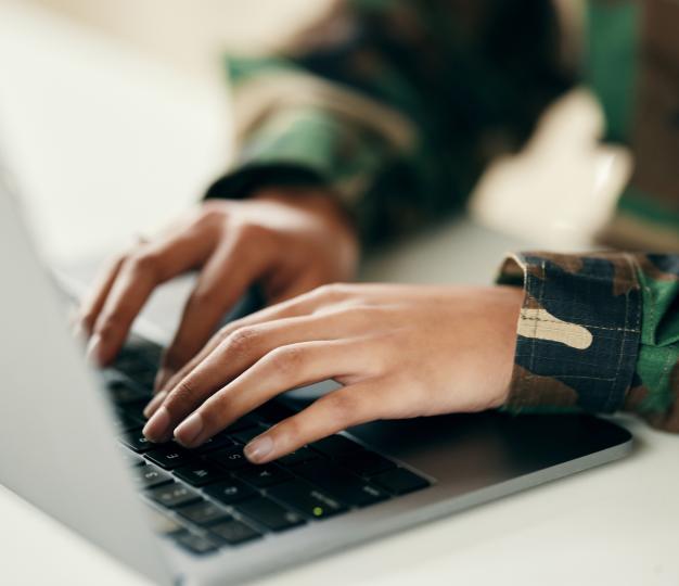 The role of the European Defence Innovation Office Hands of soldier on computer for analysis and tec
