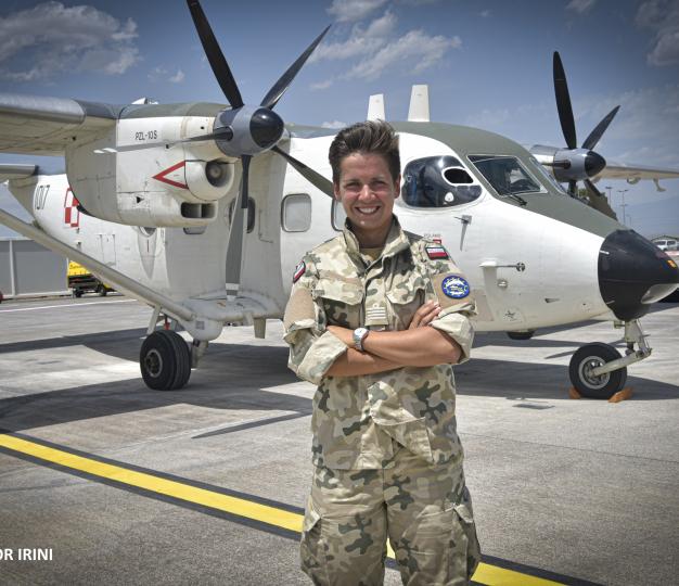 a smiling soldier in front of a military plane