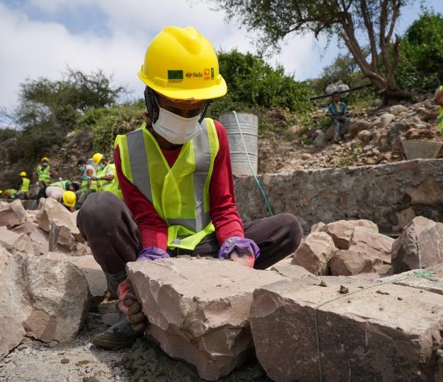 Workers build a rural road in Lahaj province