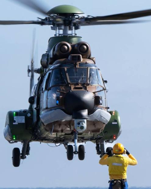 Helicopter landing on the deck of a ship.