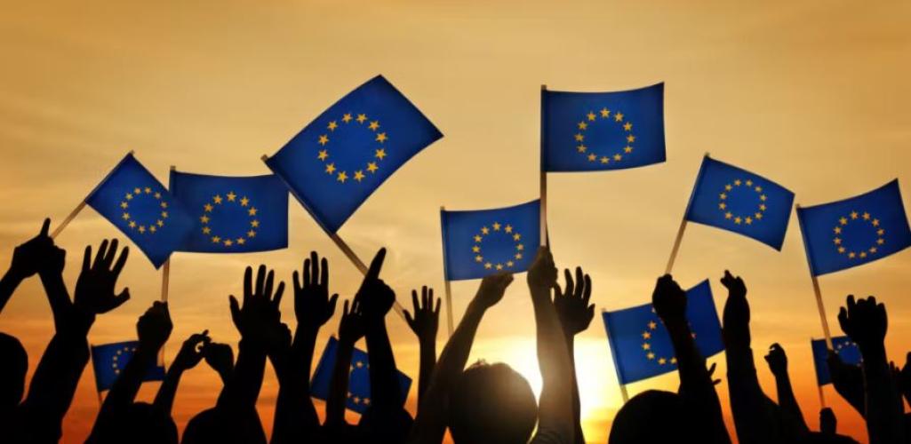 People with EU flags at sunset